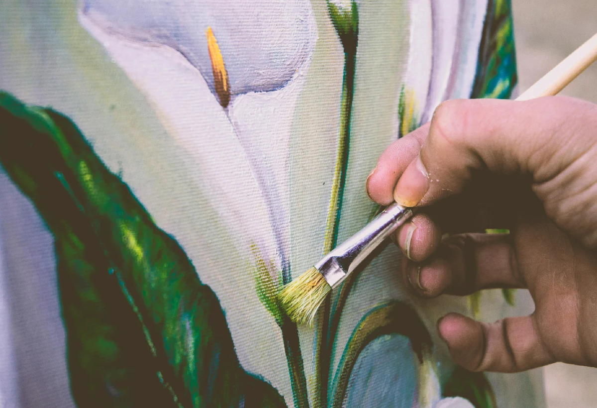 A person painting flowers with a brush.